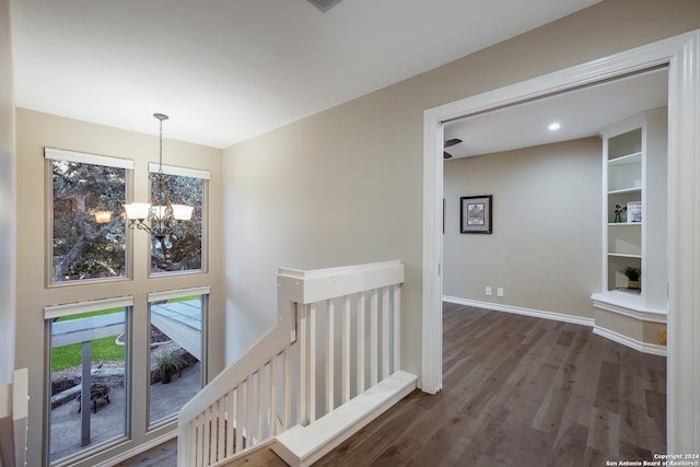 hallway with a notable chandelier and dark hardwood / wood-style flooring