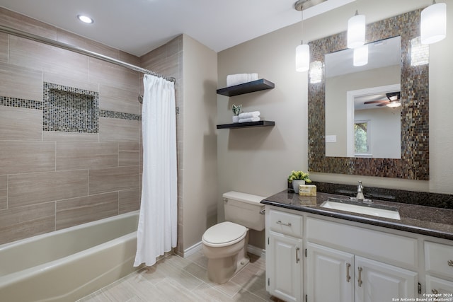 full bathroom featuring ceiling fan, shower / bath combo with shower curtain, vanity, and toilet