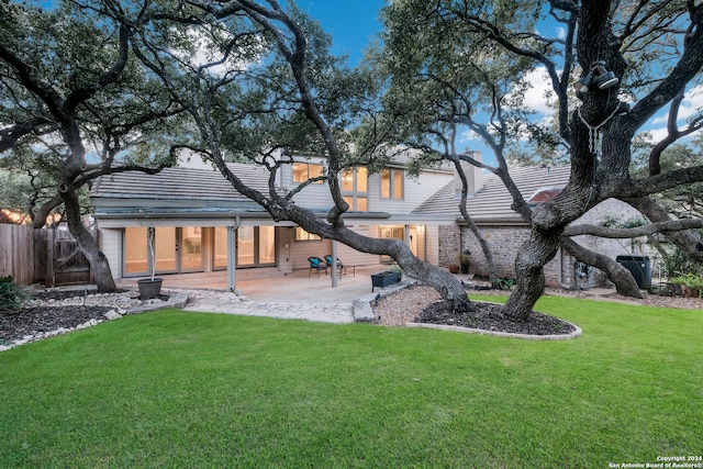 back of property with a patio area and a yard