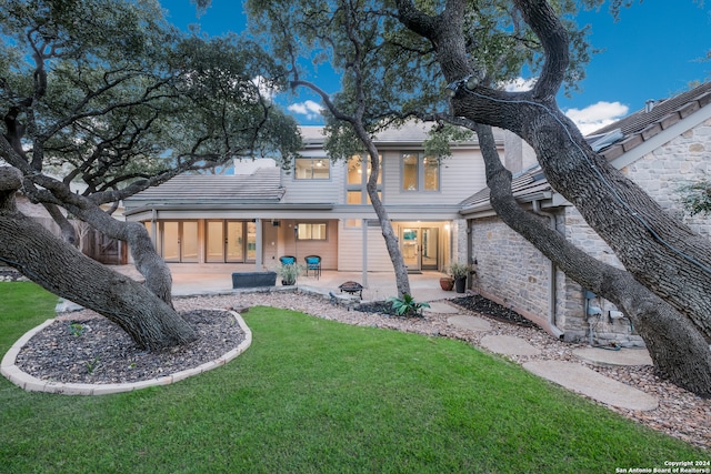 rear view of property featuring a yard and a patio