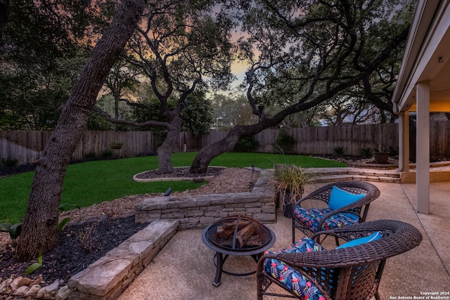 patio terrace at dusk with a lawn and a fire pit