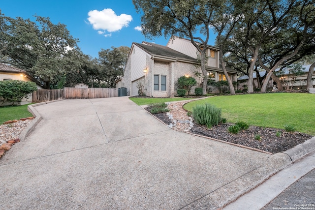 view of side of property with a yard and central AC