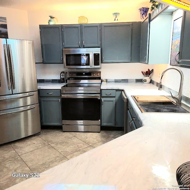 kitchen featuring gray cabinetry, sink, and stainless steel appliances