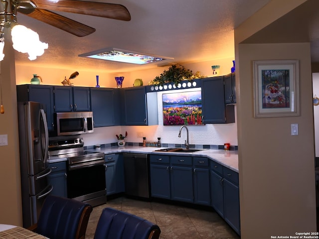15822 Lomita Springs Dr, San Antonio, TX 78247 - kitchen featuring appliances with stainless steel finishes, a sink, blue cabinetry, and ceiling fan