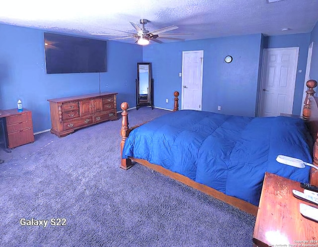 carpeted bedroom featuring ceiling fan and a textured ceiling