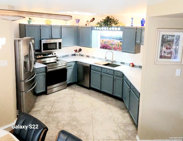 kitchen featuring blue cabinetry, appliances with stainless steel finishes, and sink