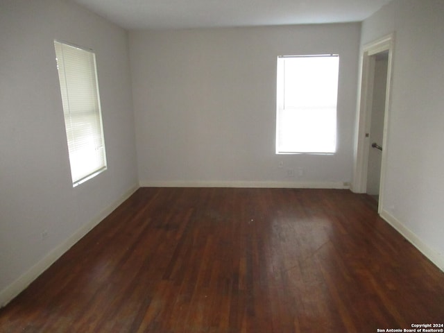 unfurnished room with dark hardwood / wood-style flooring and plenty of natural light