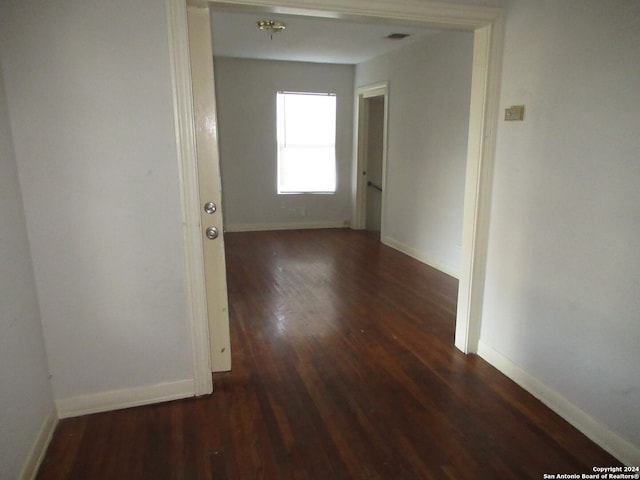 corridor with dark hardwood / wood-style flooring