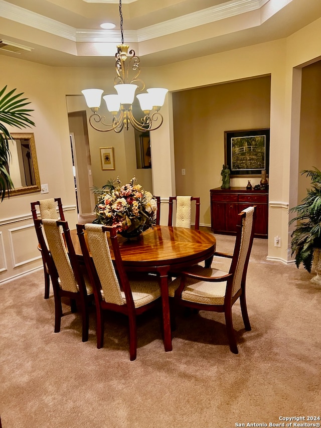 dining room featuring crown molding, light carpet, and a tray ceiling