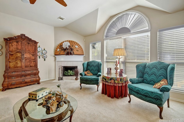 sitting room featuring carpet, ceiling fan, lofted ceiling, and a tile fireplace