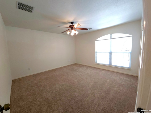 spare room with ceiling fan and carpet