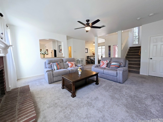 living room with light carpet, ceiling fan, and a brick fireplace