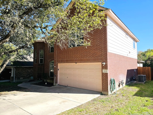 view of home's exterior with central AC unit and a garage