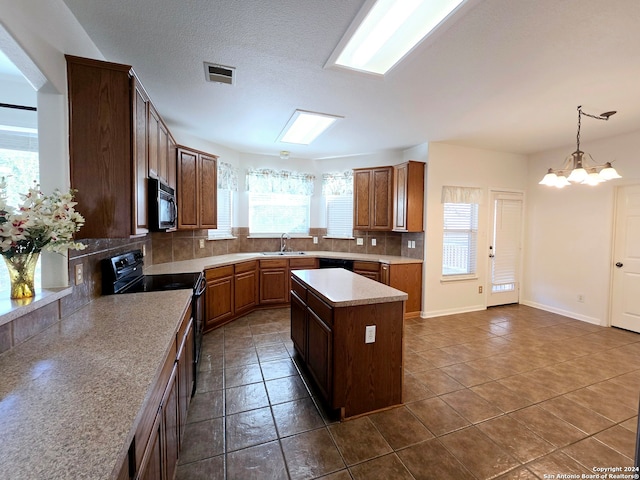 kitchen featuring decorative backsplash, a center island, plenty of natural light, and black appliances