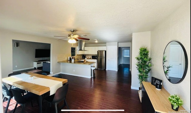 dining room featuring a textured ceiling, ceiling fan, and dark wood-type flooring