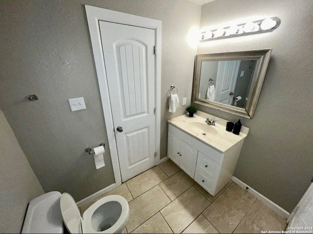 bathroom featuring tile patterned flooring, vanity, and toilet