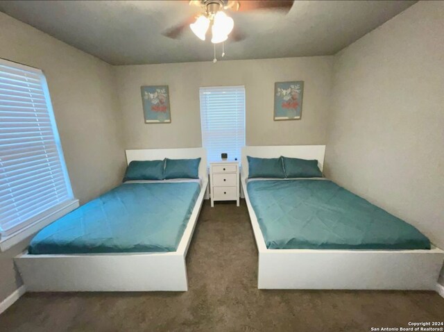 bedroom with dark colored carpet and ceiling fan