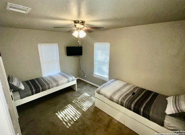 bedroom featuring dark carpet and ceiling fan