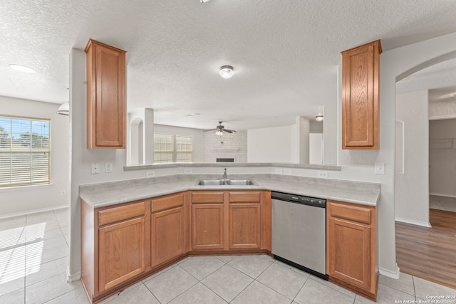 kitchen with a textured ceiling, stainless steel dishwasher, plenty of natural light, and sink