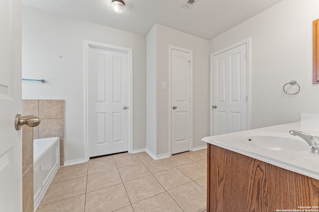 bathroom featuring tile patterned floors, a washtub, and vanity