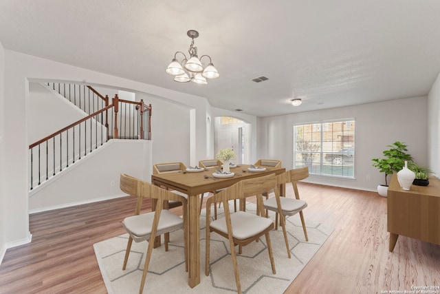 dining room with wood-type flooring and a notable chandelier