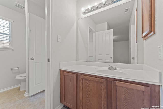 bathroom featuring tile patterned floors, vanity, and toilet