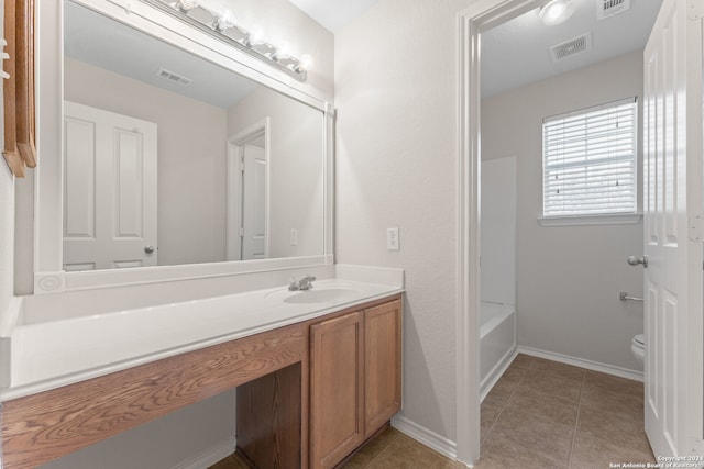 bathroom with tile patterned flooring, vanity, and toilet