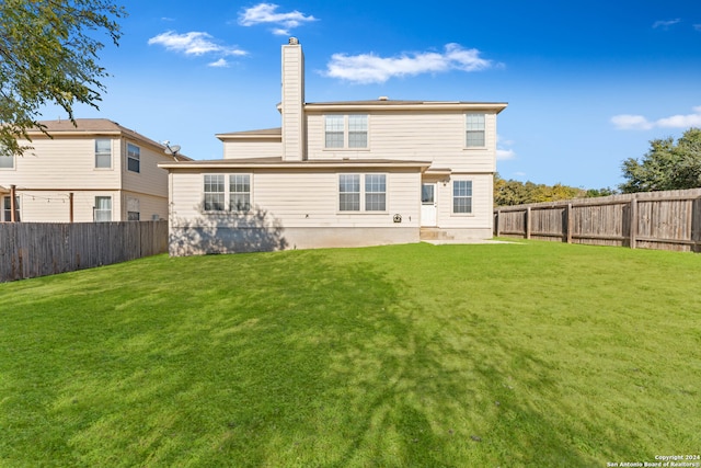 back of house with a lawn