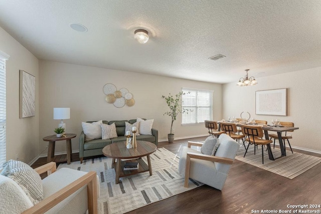 living room with hardwood / wood-style floors, a notable chandelier, and a textured ceiling