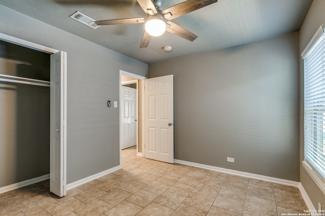 unfurnished bedroom with a closet and ceiling fan