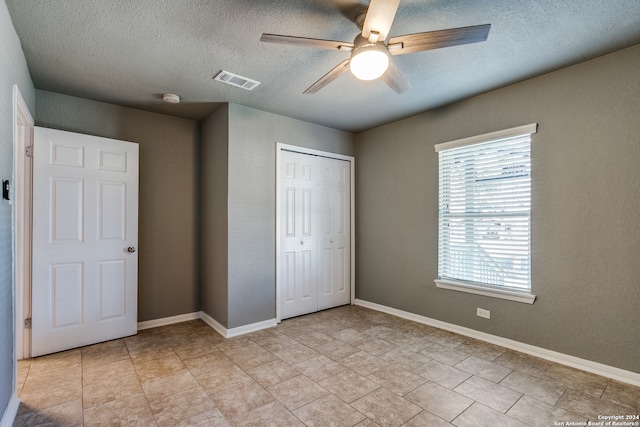 unfurnished bedroom featuring ceiling fan, a closet, and a textured ceiling