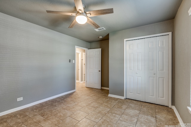 unfurnished bedroom featuring a textured ceiling, a closet, and ceiling fan