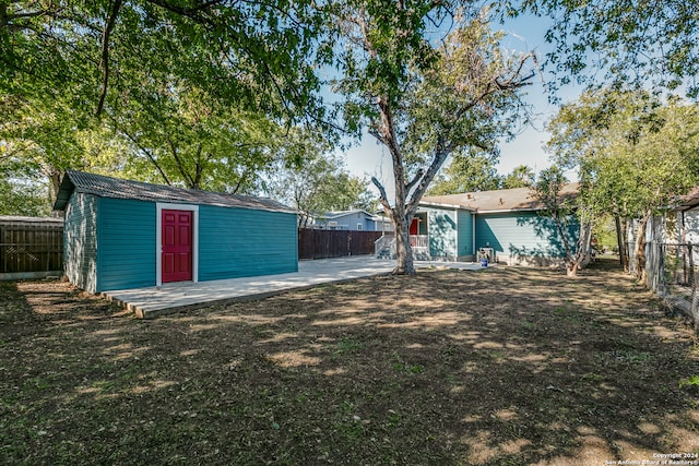 view of yard featuring a patio and a storage shed