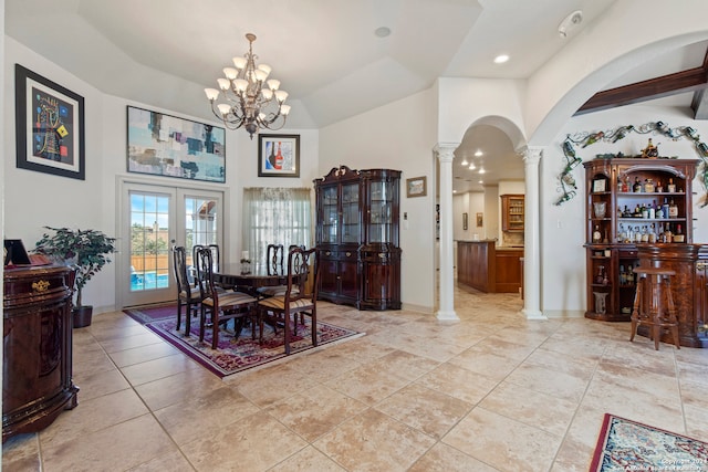 dining area featuring french doors, high vaulted ceiling, decorative columns, and an inviting chandelier