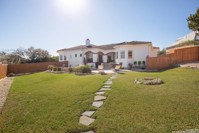 rear view of house featuring a yard, a patio, and an outdoor hangout area