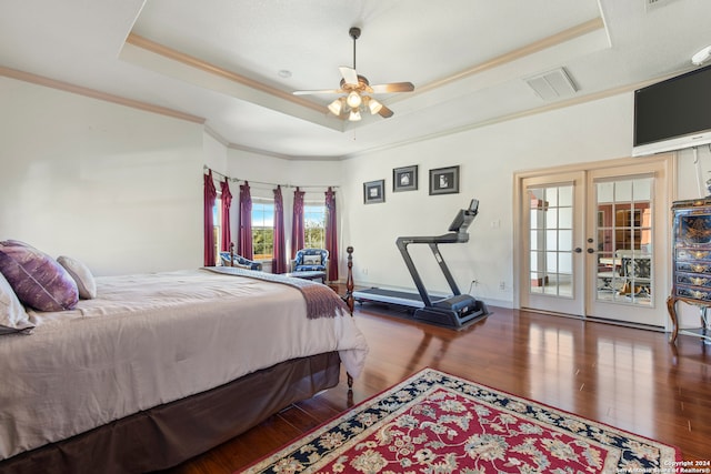 bedroom with access to exterior, hardwood / wood-style floors, a tray ceiling, and ceiling fan