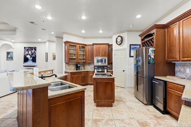 kitchen with stainless steel appliances, crown molding, a center island with sink, and sink