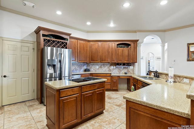 kitchen featuring kitchen peninsula, stainless steel refrigerator with ice dispenser, black electric stovetop, decorative columns, and ornamental molding