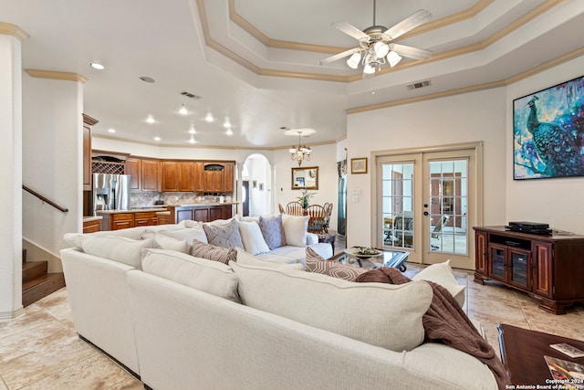 living room featuring a raised ceiling, ceiling fan, french doors, and ornamental molding