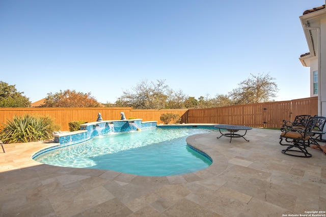 view of pool with pool water feature and a patio area