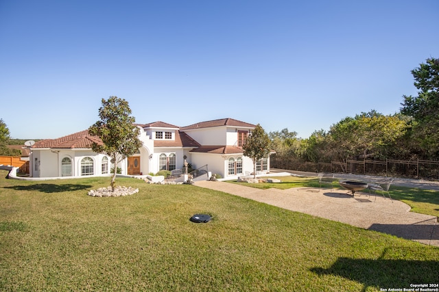 mediterranean / spanish-style house with a patio area and a front lawn