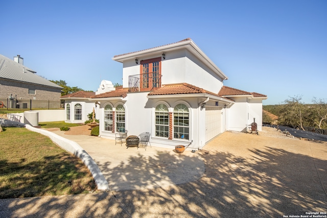 back of house featuring a balcony and a garage