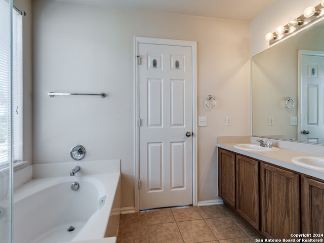 bathroom with tile patterned flooring, vanity, and a washtub