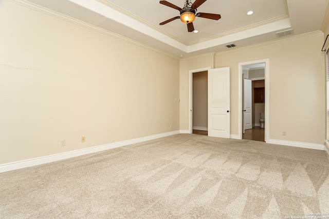 unfurnished bedroom featuring a tray ceiling, ceiling fan, crown molding, and carpet