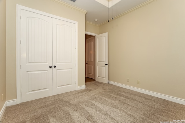 unfurnished bedroom with carpet flooring, a closet, and crown molding