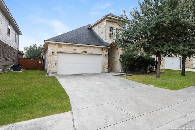 view of front of property featuring a front lawn, central AC unit, and a garage