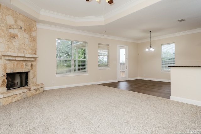 unfurnished living room featuring a fireplace, hardwood / wood-style floors, ceiling fan with notable chandelier, and ornamental molding