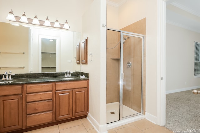 bathroom with tile patterned floors, vanity, ornamental molding, and walk in shower