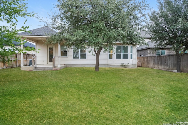 rear view of property with a yard