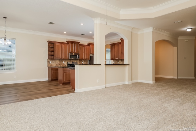 kitchen with crown molding, hanging light fixtures, decorative backsplash, light wood-type flooring, and stainless steel appliances